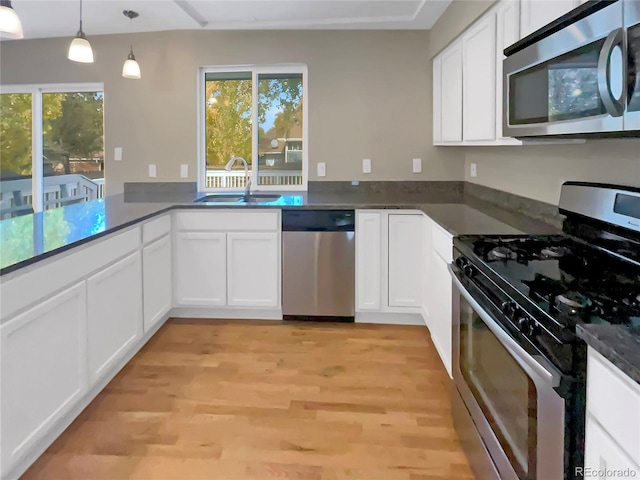 kitchen with white cabinetry, decorative light fixtures, stainless steel appliances, and plenty of natural light