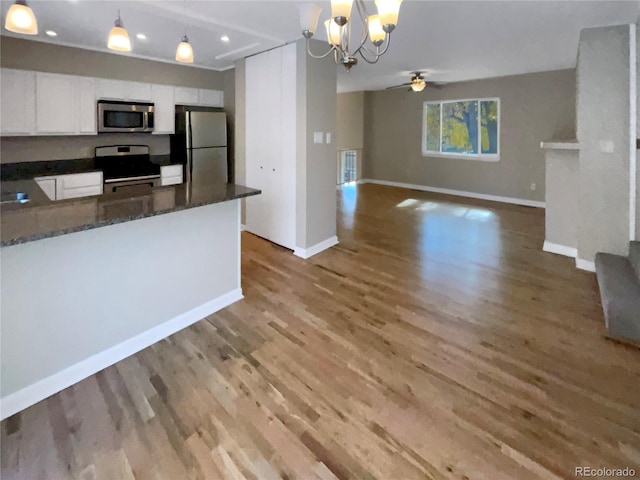 kitchen with light wood-type flooring, appliances with stainless steel finishes, pendant lighting, and white cabinets