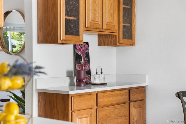 6506 Lee St, Arvada, CO 80004 - kitchen featuring light countertops, glass insert cabinets, and brown cabinets