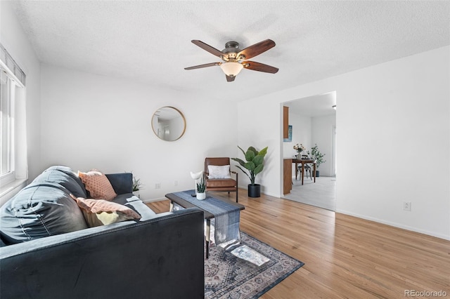6506 Lee St, Arvada, CO 80004 - living room with a ceiling fan, light wood-type flooring, a textured ceiling, and baseboards