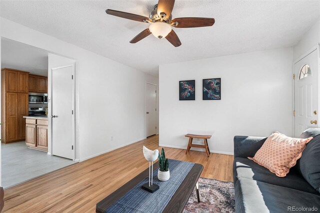 6506 Lee St, Arvada, CO 80004 - living area with a ceiling fan, light wood-type flooring, and baseboards