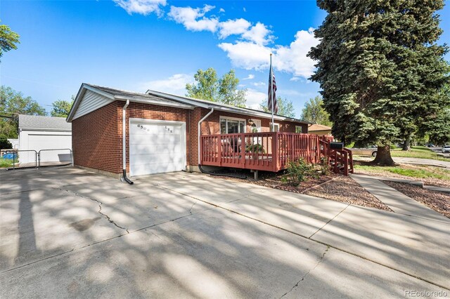 6506 Lee St, Arvada, CO 80004 - view of front facade with brick siding, an attached garage, concrete driveway, and a deck