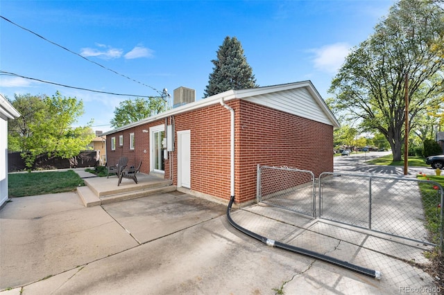 6506 Lee St, Arvada, CO 80004 - view of home's exterior featuring brick siding, fence, a patio, and a gate