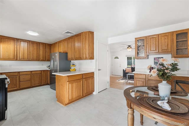 6506 Lee St, Arvada, CO 80004 - kitchen with brown cabinets, freestanding refrigerator, and light countertops