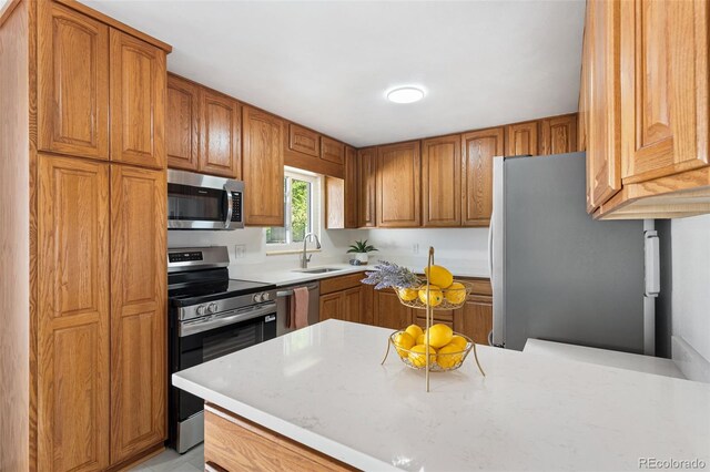 6506 Lee St, Arvada, CO 80004 - kitchen featuring stainless steel appliances, a sink, brown cabinets, and light countertops