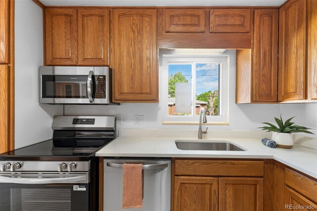 6506 Lee St, Arvada, CO 80004 - kitchen featuring stainless steel appliances, a sink, brown cabinetry, and light countertops