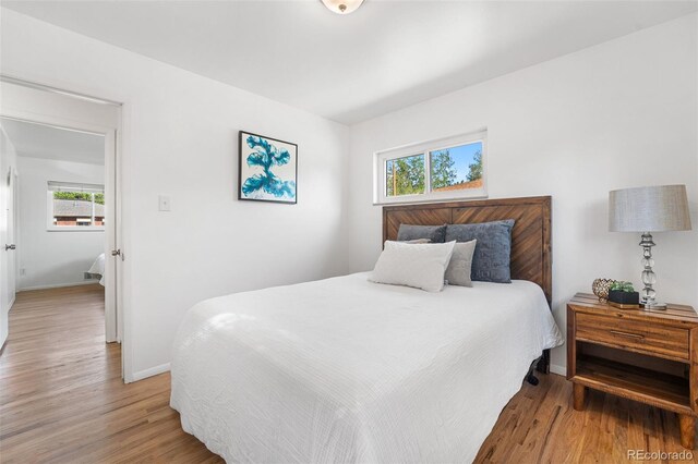 6506 Lee St, Arvada, CO 80004 - bedroom with multiple windows, baseboards, and light wood-style floors