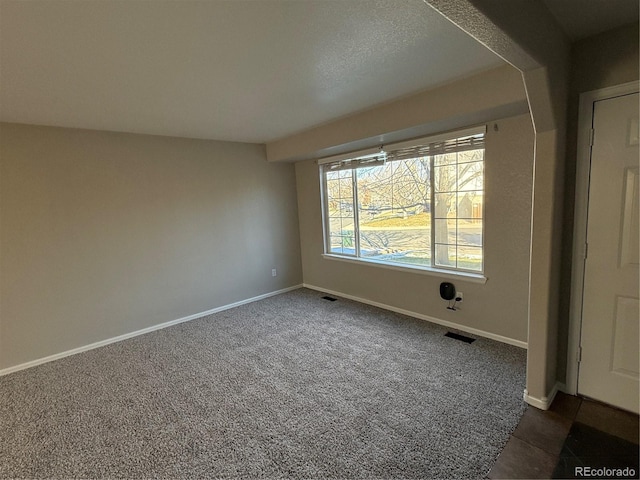 unfurnished room featuring dark carpet