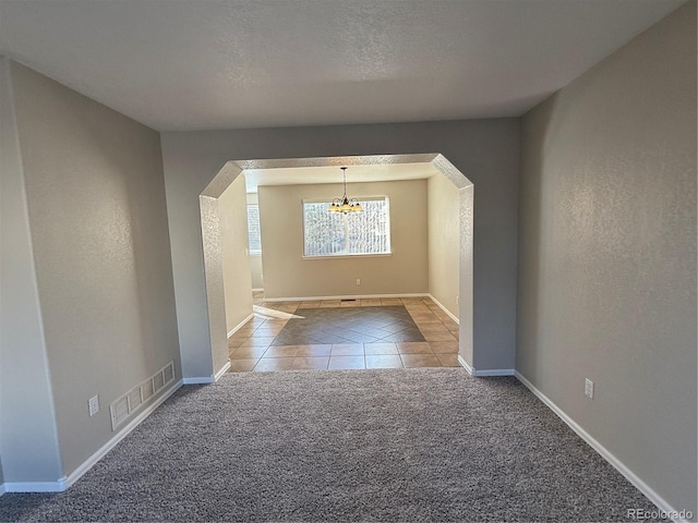 interior space featuring a textured ceiling and a notable chandelier