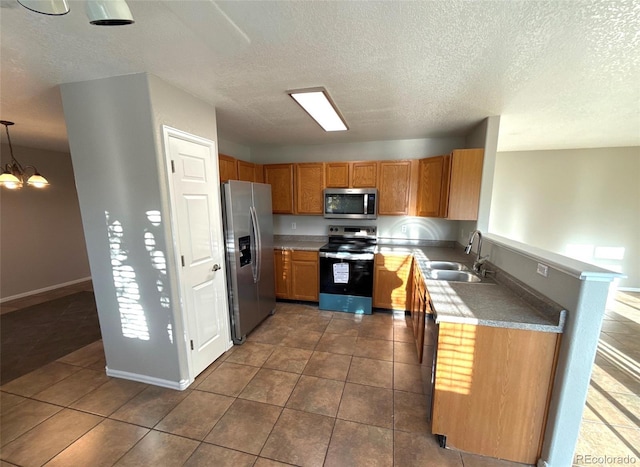 kitchen with sink, hanging light fixtures, a textured ceiling, appliances with stainless steel finishes, and a chandelier