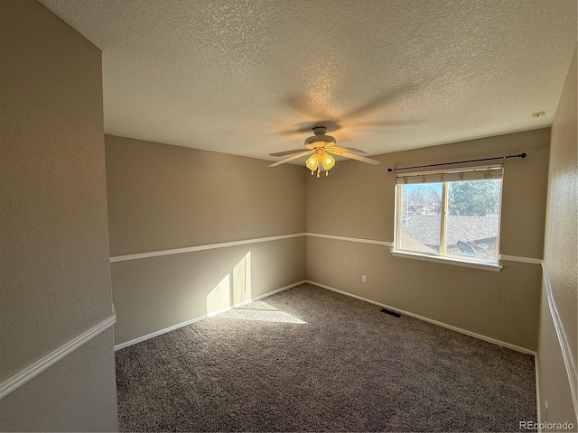 carpeted empty room featuring ceiling fan and a textured ceiling