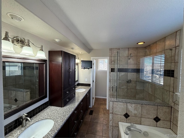 bathroom with a wealth of natural light, tile patterned flooring, vanity, and a textured ceiling