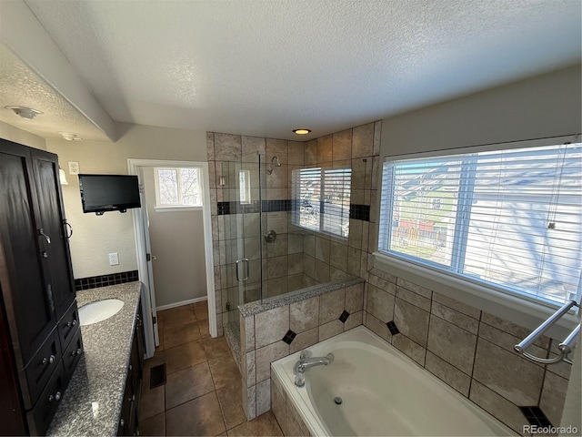 bathroom with tile patterned floors, vanity, a textured ceiling, and independent shower and bath