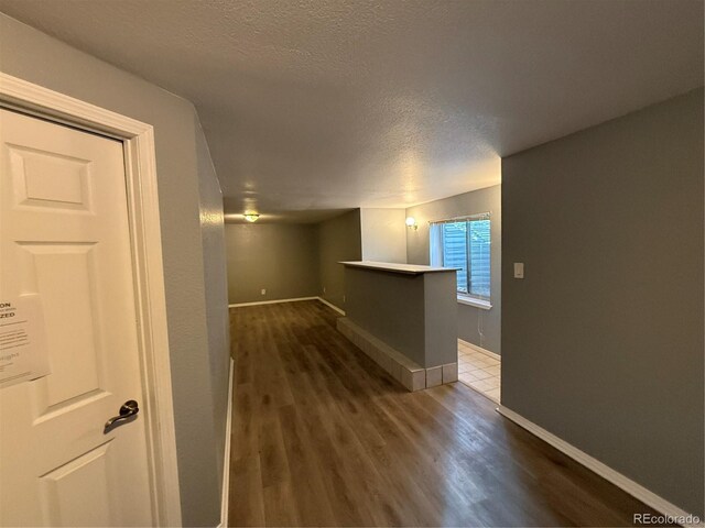 corridor featuring dark hardwood / wood-style floors and a textured ceiling