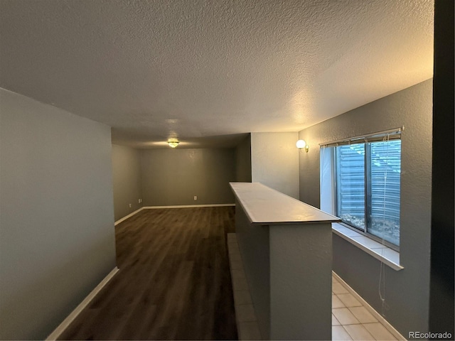 interior space with a textured ceiling and hardwood / wood-style flooring