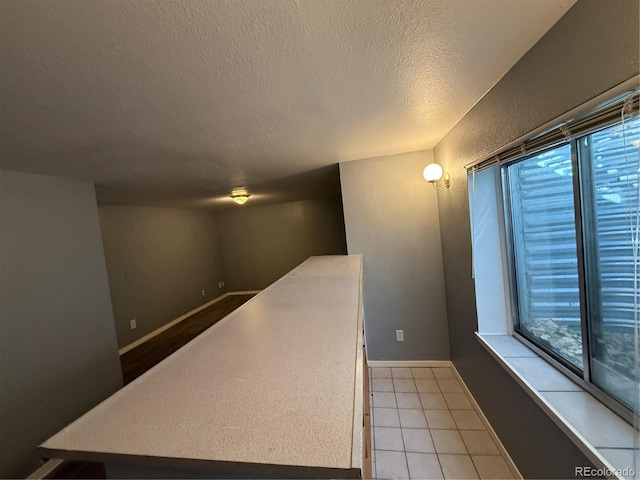 interior space with light tile patterned floors and a textured ceiling