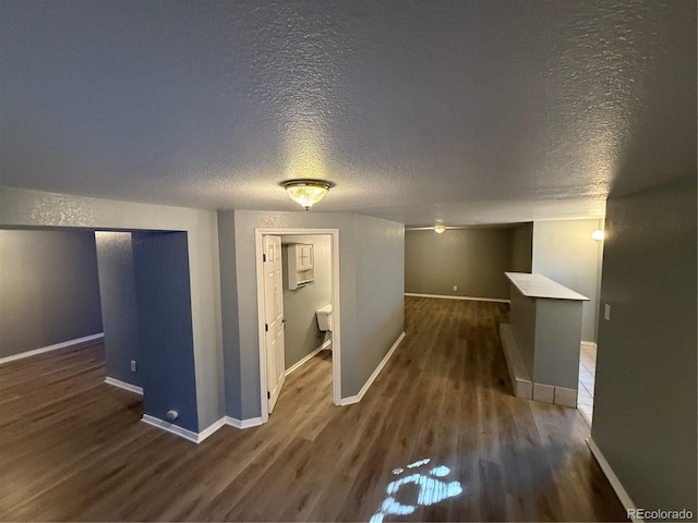 hallway featuring dark wood-type flooring and a textured ceiling