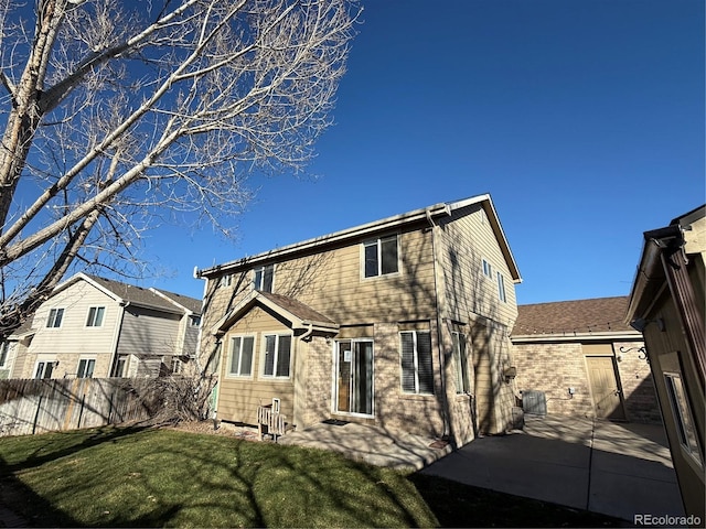 rear view of property featuring a yard and a patio area