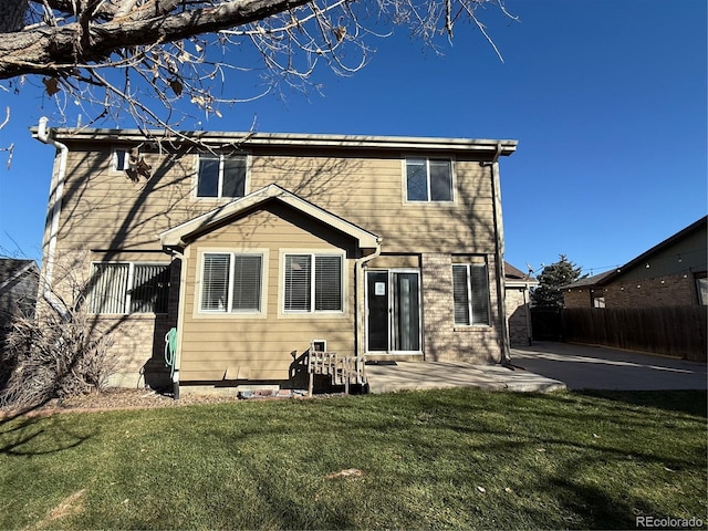 back of house with a lawn and a patio area