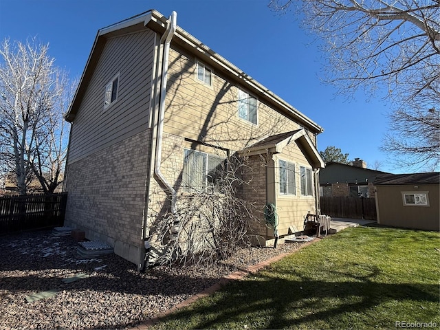 view of side of home featuring a yard and a shed