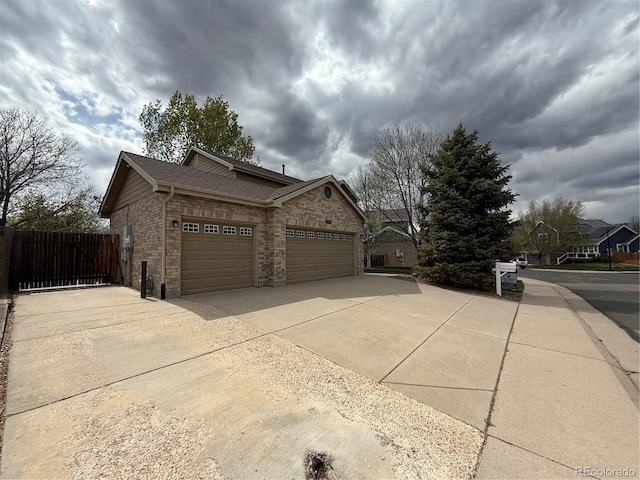 13031 Dexter St, Thornton, CO 80241 - view of home's exterior featuring brick siding, a garage, concrete driveway, and a shingled roof