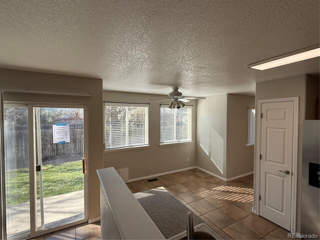 13031 Dexter St, Thornton, CO 80241 - unfurnished living room featuring a ceiling fan, plenty of natural light, tile patterned floors, a textured ceiling, and baseboards