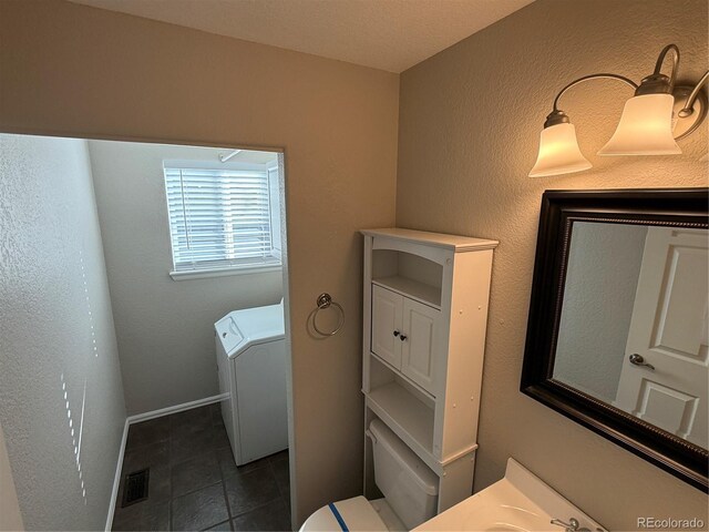 13031 Dexter St, Thornton, CO 80241 - bathroom featuring washer / dryer, tile patterned flooring, and toilet