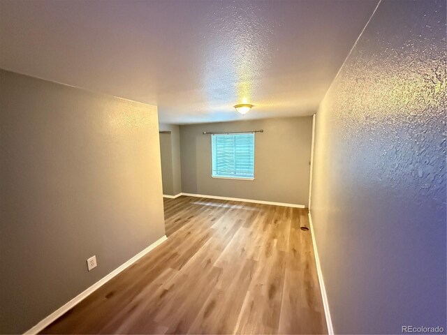 13031 Dexter St, Thornton, CO 80241 - spare room with wood finished floors, baseboards, and a textured ceiling