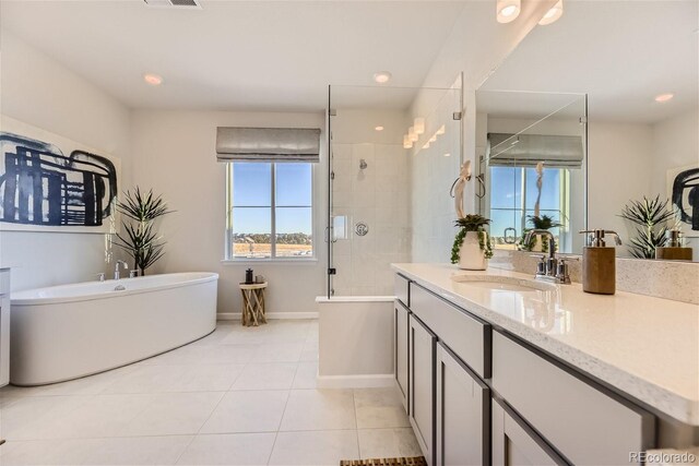 bathroom featuring vanity, baseboards, a freestanding tub, a stall shower, and tile patterned floors