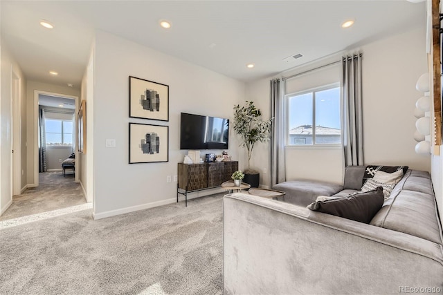 living room featuring recessed lighting, light colored carpet, visible vents, and baseboards