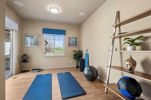 workout room with baseboards and wood finished floors