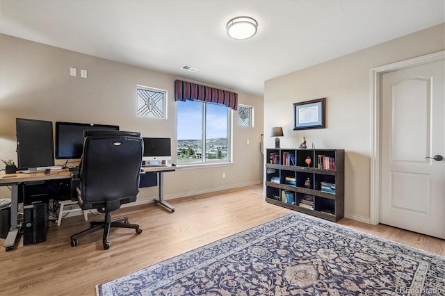 office area featuring visible vents, baseboards, and wood finished floors