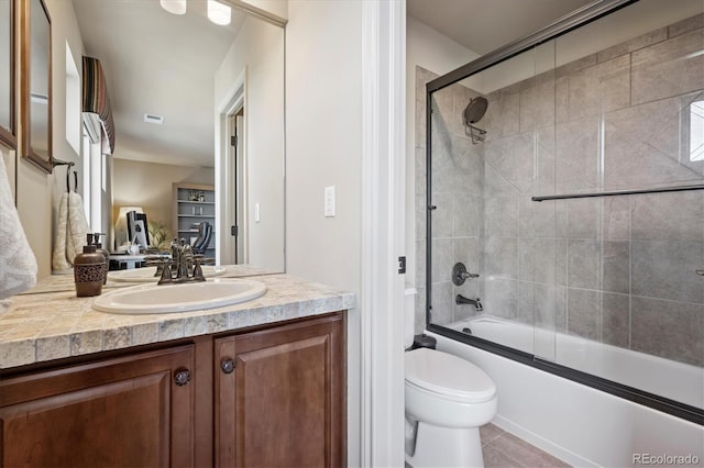 bathroom featuring vanity, toilet, tile patterned floors, combined bath / shower with glass door, and visible vents