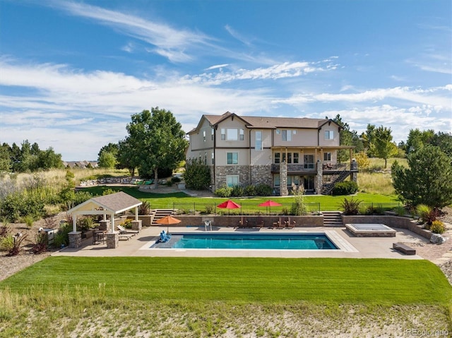 pool featuring fence, a lawn, a hot tub, a gazebo, and a patio area