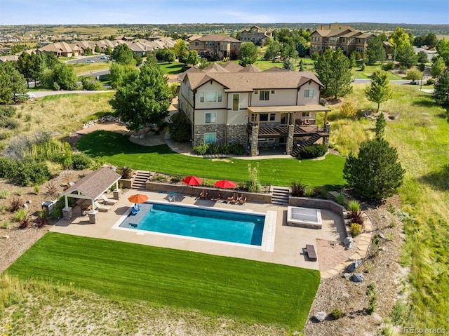 exterior space featuring a lawn, a pergola, and a residential view
