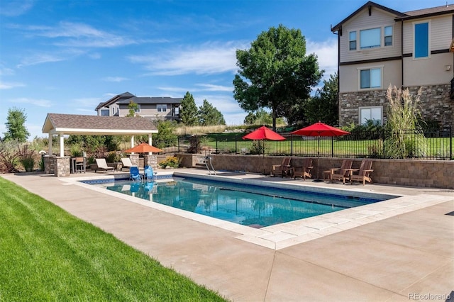 view of swimming pool with a patio area, a fenced in pool, and fence
