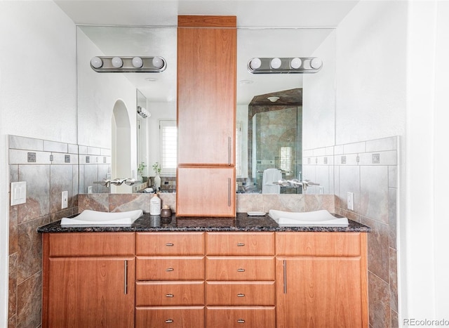 bathroom featuring vanity and tile walls