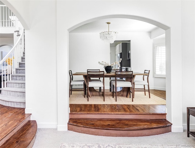 carpeted dining room featuring an inviting chandelier