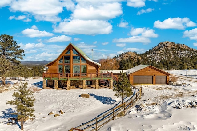 log-style house with a garage and a deck with mountain view