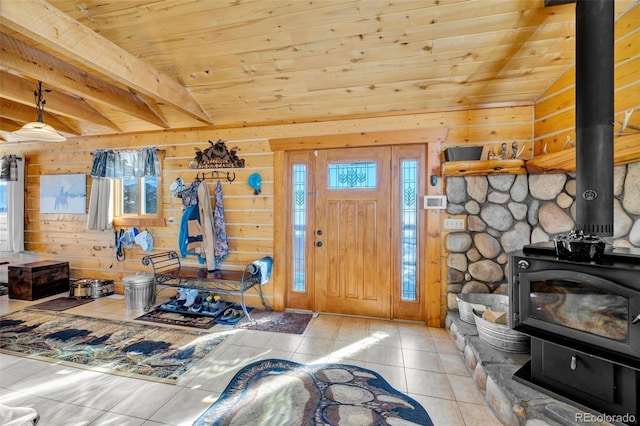 tiled entryway featuring wood ceiling, vaulted ceiling, wooden walls, and a wood stove