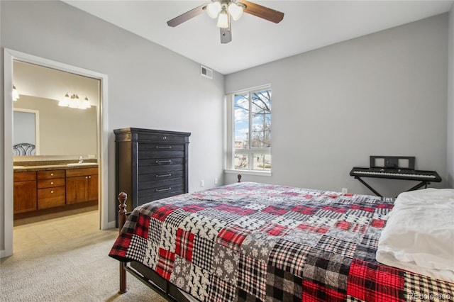 bedroom with visible vents, ensuite bathroom, light carpet, ceiling fan, and a sink