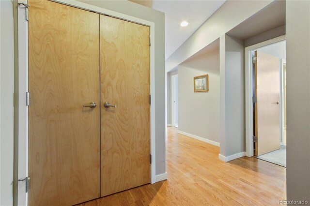 hall featuring light wood-type flooring, baseboards, and recessed lighting