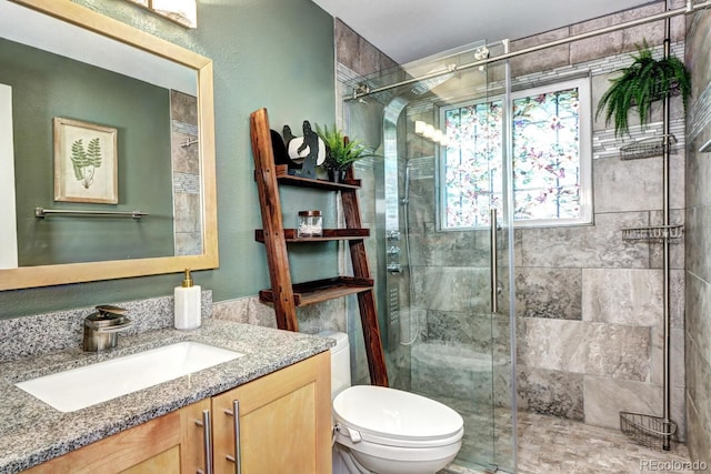 bathroom with vanity, toilet, tile walls, and a stall shower