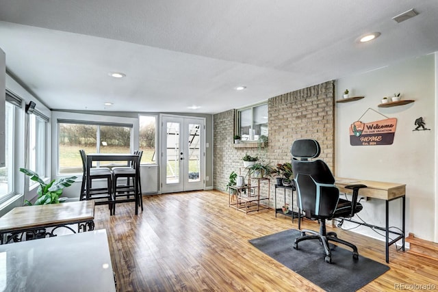 office space featuring brick wall, wood finished floors, a healthy amount of sunlight, and recessed lighting