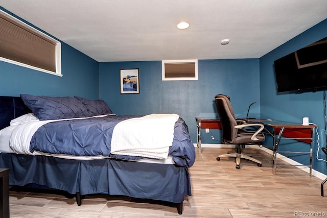 bedroom with wood finished floors, baseboards, and recessed lighting