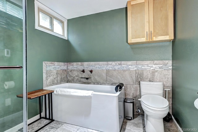 full bath featuring a stall shower, toilet, tile walls, and a bath