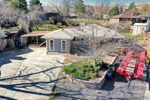 view of front facade with concrete driveway and roof with shingles