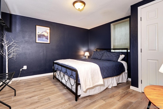 bedroom featuring wood finished floors and baseboards