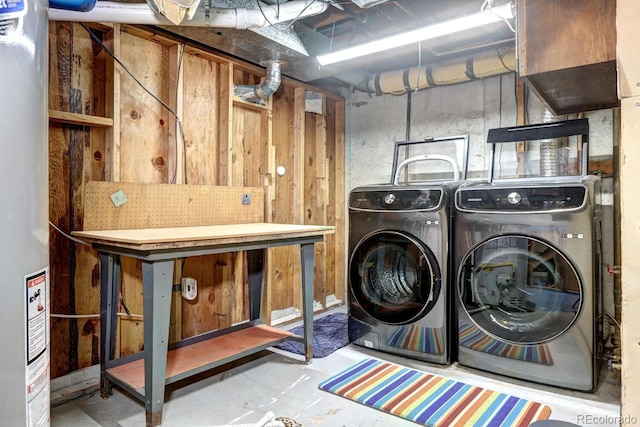 clothes washing area with laundry area, washer and clothes dryer, and gas water heater