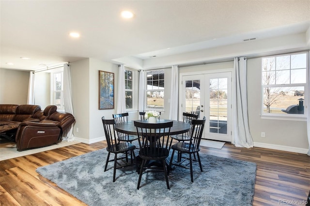 dining room featuring french doors, wood finished floors, visible vents, and baseboards